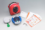 赤いAEDパッケージ、AED本体、AEDの説明書が映っています